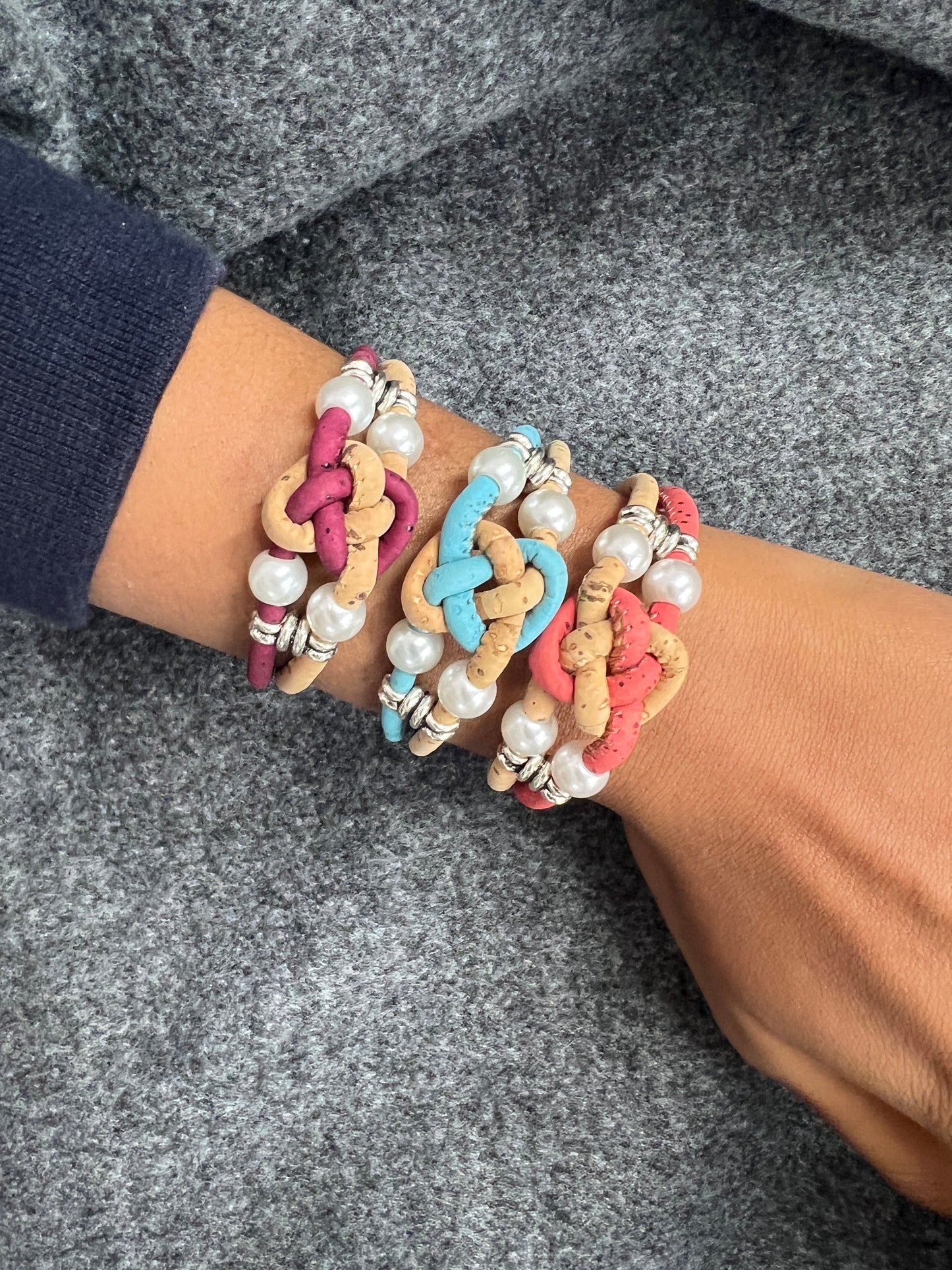 Ces bracelets sont composés de deux brins en liège naturel, agrémentés d'une perle d'eau douce pour une touche d'élégance. Les ferrures en acier inoxydable ajoutent de la solidité et de la durabilité à l'ensemble. C'est une option écologique et éthique pour les amateurs de bijoux de qualité.