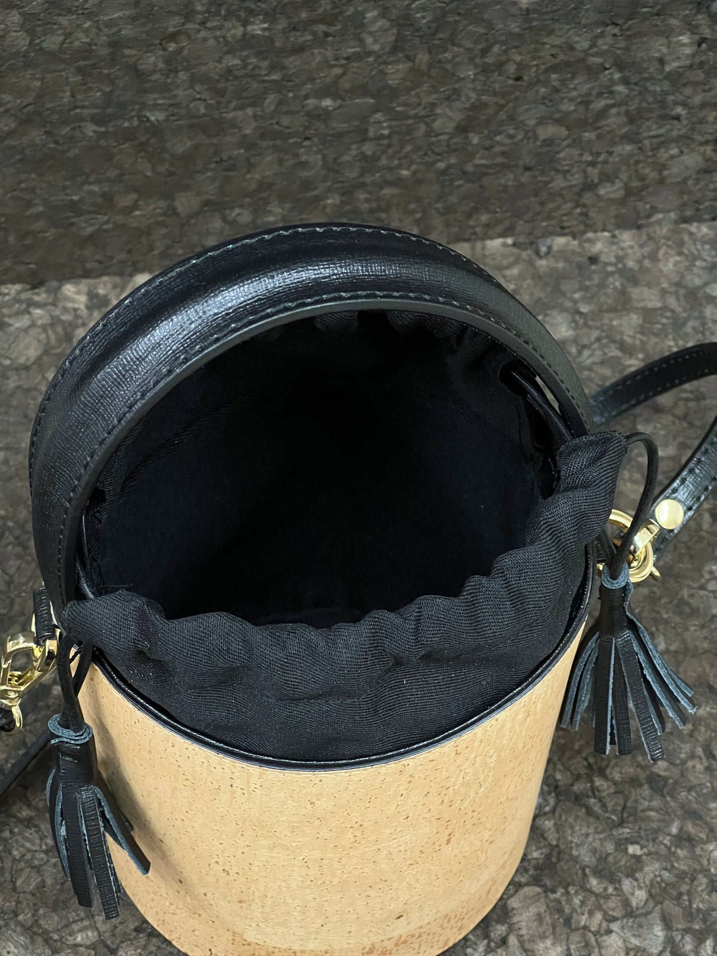 Laissez-vous séduire par ce magnifique sac seau en cuir de liège éco-responsable, créé avec passion et savoir-faire par une talentueuse créatrice originaire de Sardaigne. Le contraste élégant entre le noir et le liège brut confère à ce sac une allure unique et naturelle. Sa bandoulière en cuir réglable et détachable offre une polyvalence pratique pour le porter selon vos préférences.