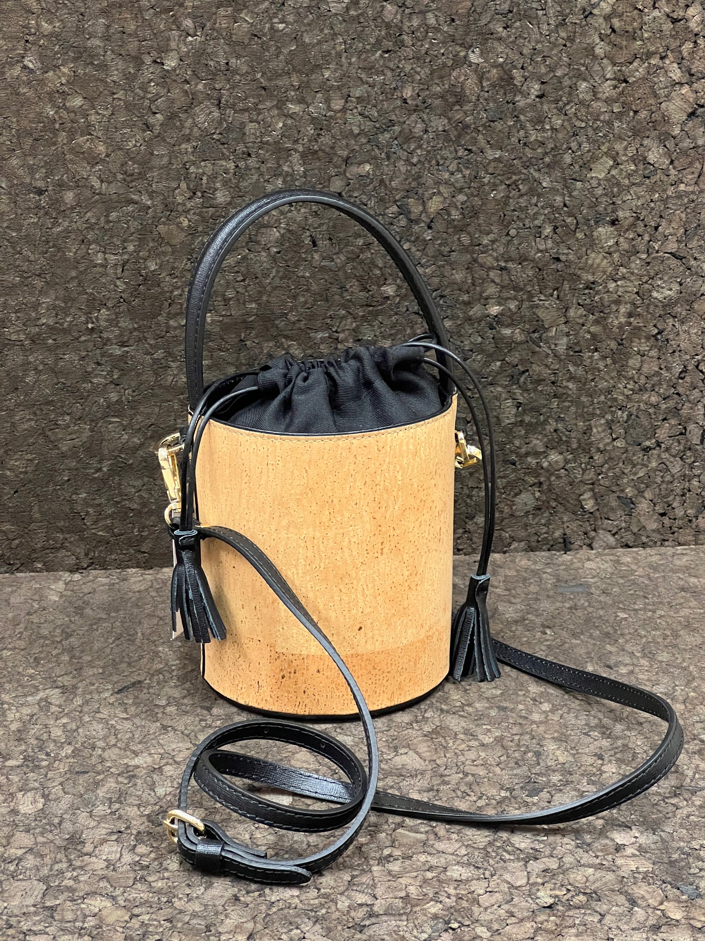Laissez-vous séduire par ce magnifique sac seau en cuir de liège éco-responsable, créé avec passion et savoir-faire par une talentueuse créatrice originaire de Sardaigne. Le contraste élégant entre le noir et le liège brut confère à ce sac une allure unique et naturelle. Sa bandoulière en cuir réglable et détachable offre une polyvalence pratique pour le porter selon vos préférences.