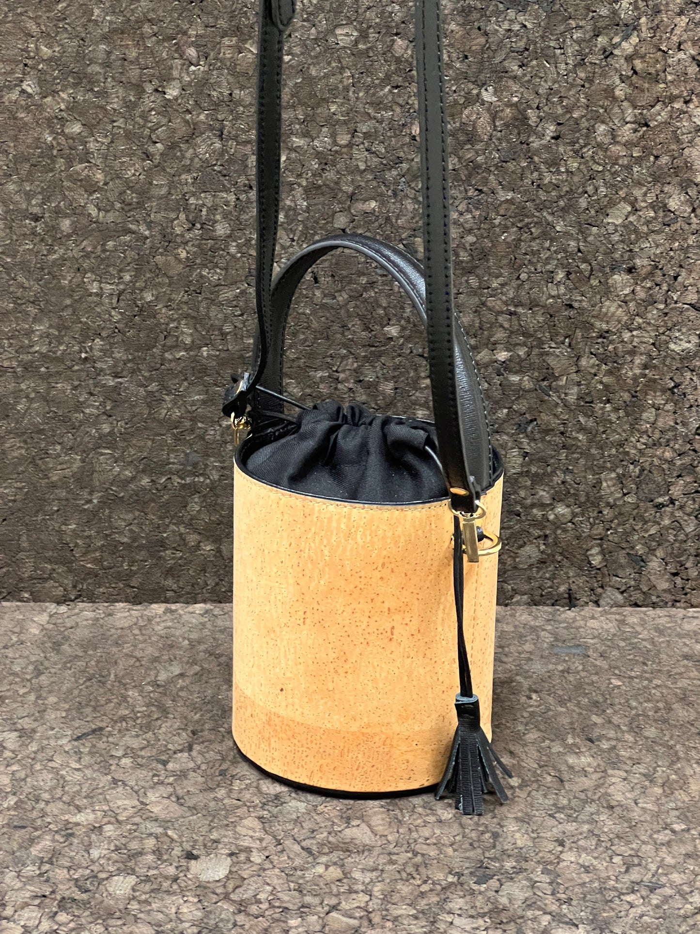 Laissez-vous séduire par ce magnifique sac seau en cuir de liège éco-responsable, créé avec passion et savoir-faire par une talentueuse créatrice originaire de Sardaigne. Le contraste élégant entre le noir et le liège brut confère à ce sac une allure unique et naturelle. Sa bandoulière en cuir réglable et détachable offre une polyvalence pratique pour le porter selon vos préférences.
