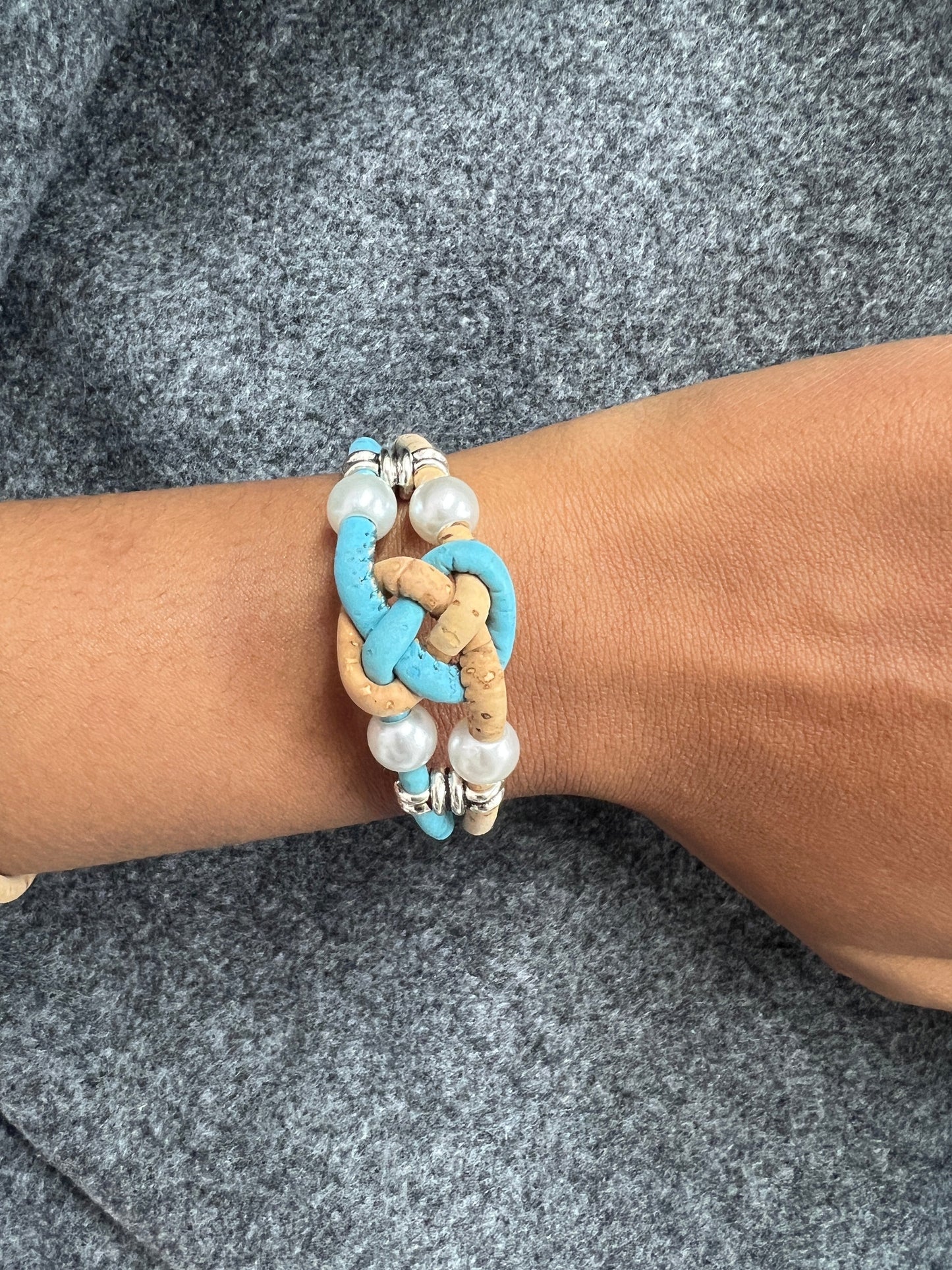 Ces bracelets sont composés de deux brins en liège naturel, agrémentés d'une perle d'eau douce pour une touche d'élégance. Les ferrures en acier inoxydable ajoutent de la solidité et de la durabilité à l'ensemble. C'est une option écologique et éthique pour les amateurs de bijoux de qualité.