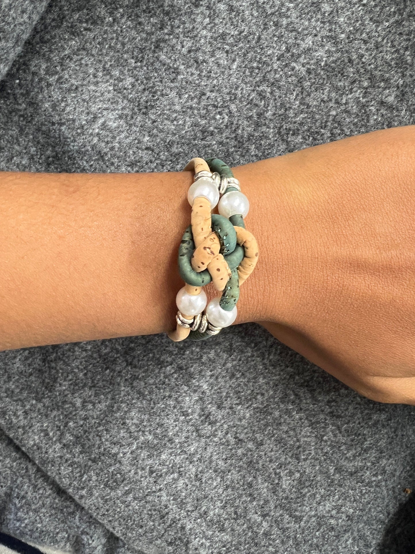 Ces bracelets sont composés de deux brins en liège naturel, agrémentés d'une perle d'eau douce pour une touche d'élégance. Les ferrures en acier inoxydable ajoutent de la solidité et de la durabilité à l'ensemble. C'est une option écologique et éthique pour les amateurs de bijoux de qualité.