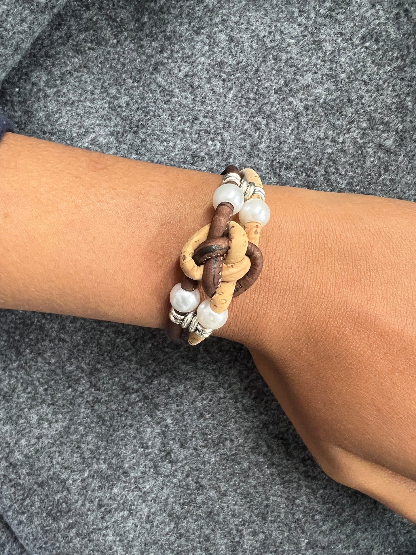 Ces bracelets sont composés de deux brins en liège naturel, agrémentés d'une perle d'eau douce pour une touche d'élégance. Les ferrures en acier inoxydable ajoutent de la solidité et de la durabilité à l'ensemble. C'est une option écologique et éthique pour les amateurs de bijoux de qualité.