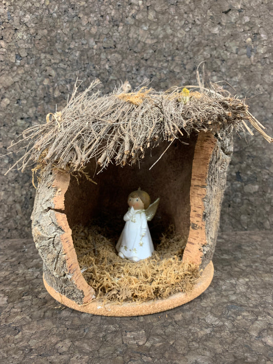 Crèche en liège et en bois, le toit est composé de morceaux de bâtons, de la mousse végétale à l'intérieur avec l'ange posé dessus