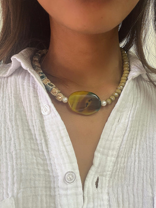 Le collier de la marque Citron Caviar est une pièce unique, faite à la main par une créatrice de Porto Vecchio. Il présente une combinaison de différentes pierres précieuses et semi-précieuses, offrant un design raffiné et intemporel. Chaque collier est une véritable œuvre d'art, témoignant du savoir-faire et de la passion investis dans sa création. C'est un bijou qui célèbre la beauté de la nature et exprime votre individualité avec élégance.