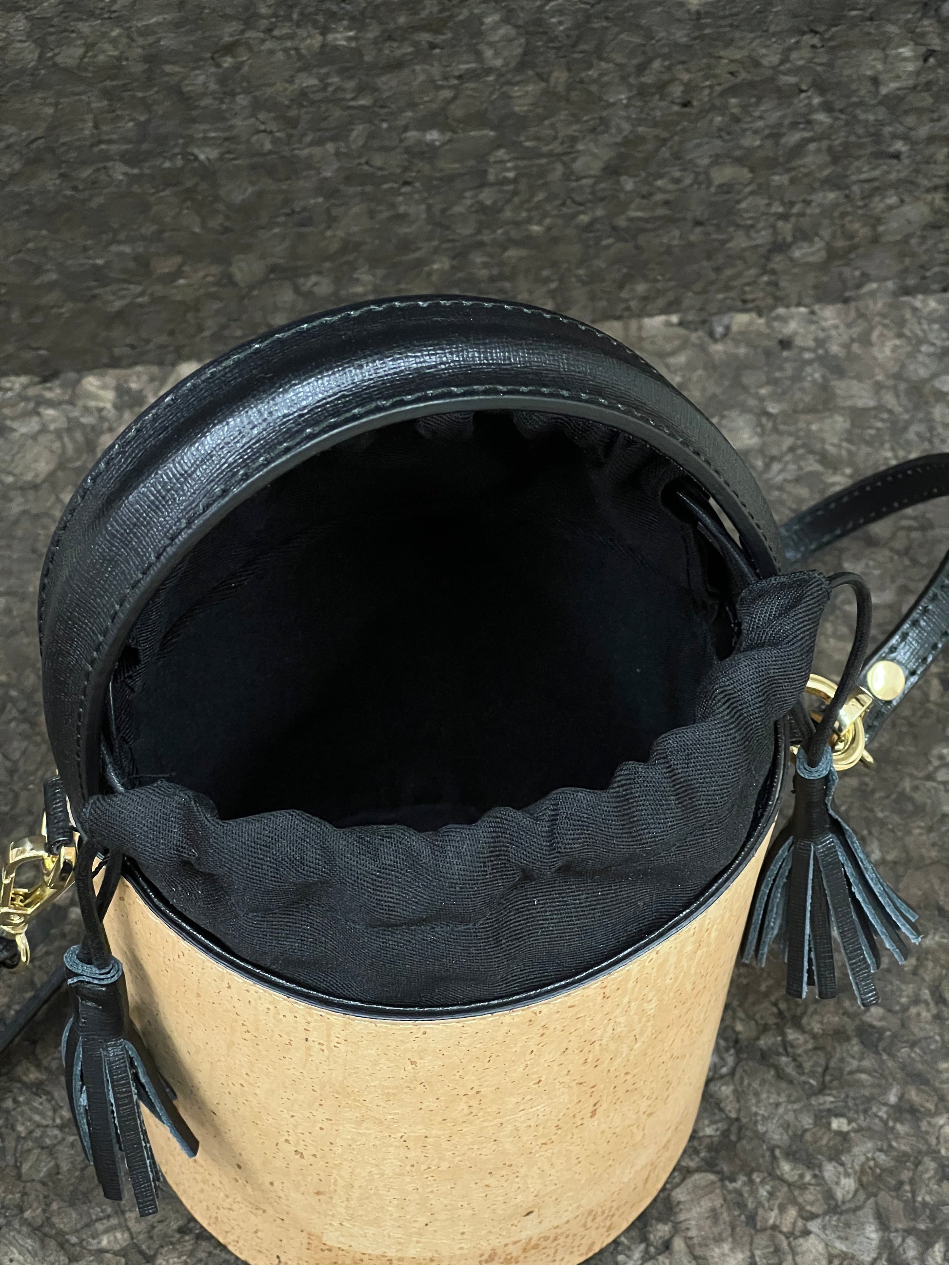 Laissez-vous séduire par ce magnifique sac seau en cuir de liège éco-responsable, créé avec passion et savoir-faire par une talentueuse créatrice originaire de Sardaigne. Le contraste élégant entre le noir et le liège brut confère à ce sac une allure unique et naturelle. Sa bandoulière en cuir réglable et détachable offre une polyvalence pratique pour le porter selon vos préférences. 