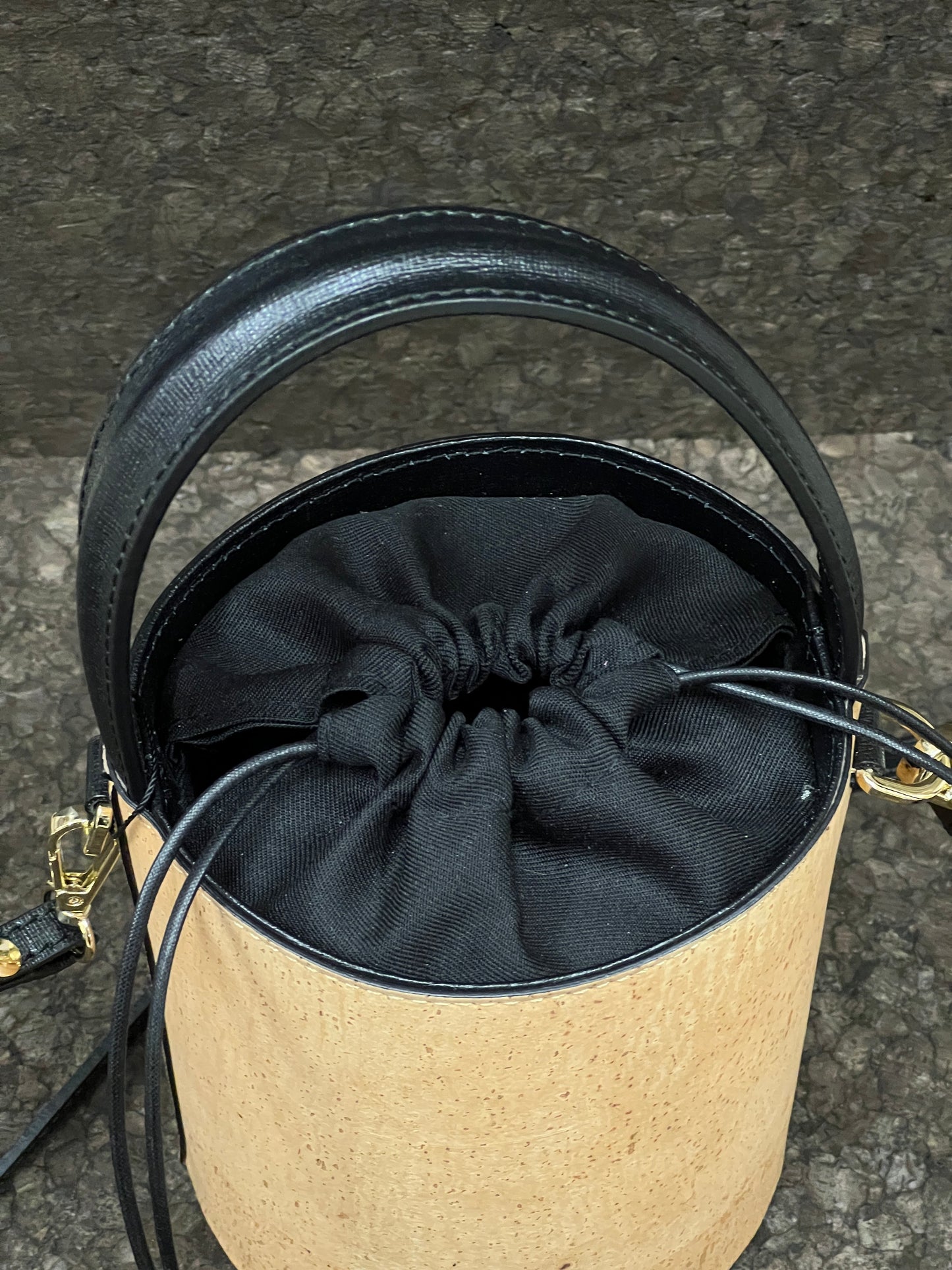 Laissez-vous séduire par ce magnifique sac seau en cuir de liège éco-responsable, créé avec passion et savoir-faire par une talentueuse créatrice originaire de Sardaigne. Le contraste élégant entre le noir et le liège brut confère à ce sac une allure unique et naturelle. Sa bandoulière en cuir réglable et détachable offre une polyvalence pratique pour le porter selon vos préférences. 