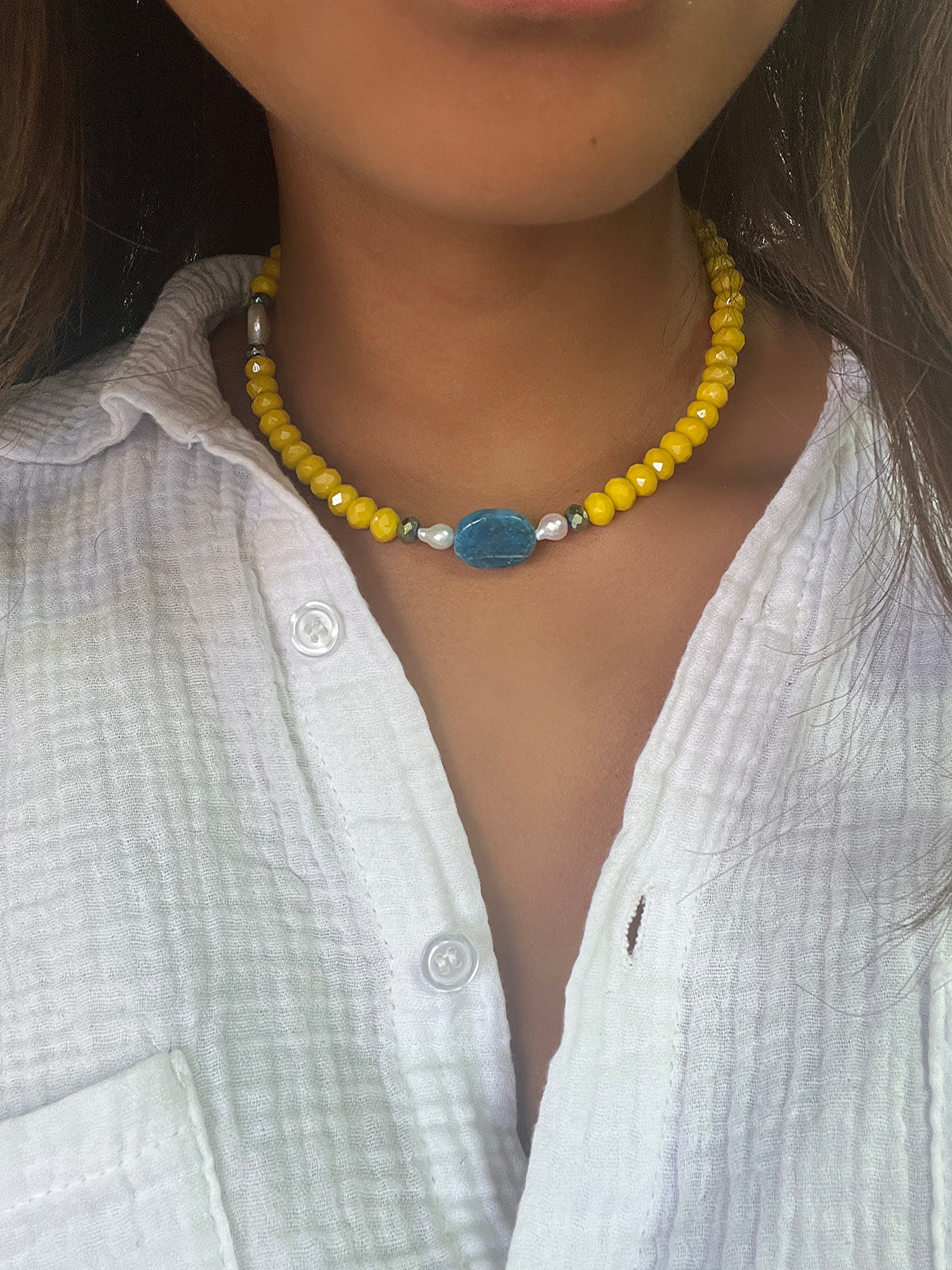 Le collier de la marque Citron Caviar est une pièce unique, faite à la main par une créatrice de Porto Vecchio. Il présente une combinaison de différentes pierres précieuses et semi-précieuses, offrant un design raffiné et intemporel. Chaque collier est une véritable œuvre d'art, témoignant du savoir-faire et de la passion investis dans sa création. C'est un bijou qui célèbre la beauté de la nature et exprime votre individualité avec élégance.